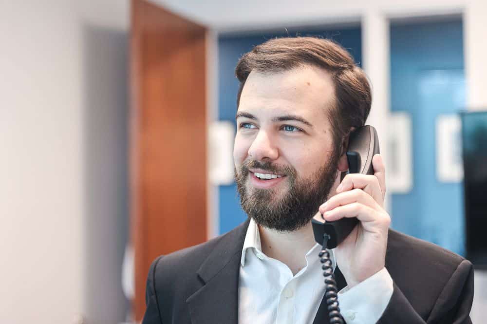 A healthcare worker engages in patient enrollment over the phone.