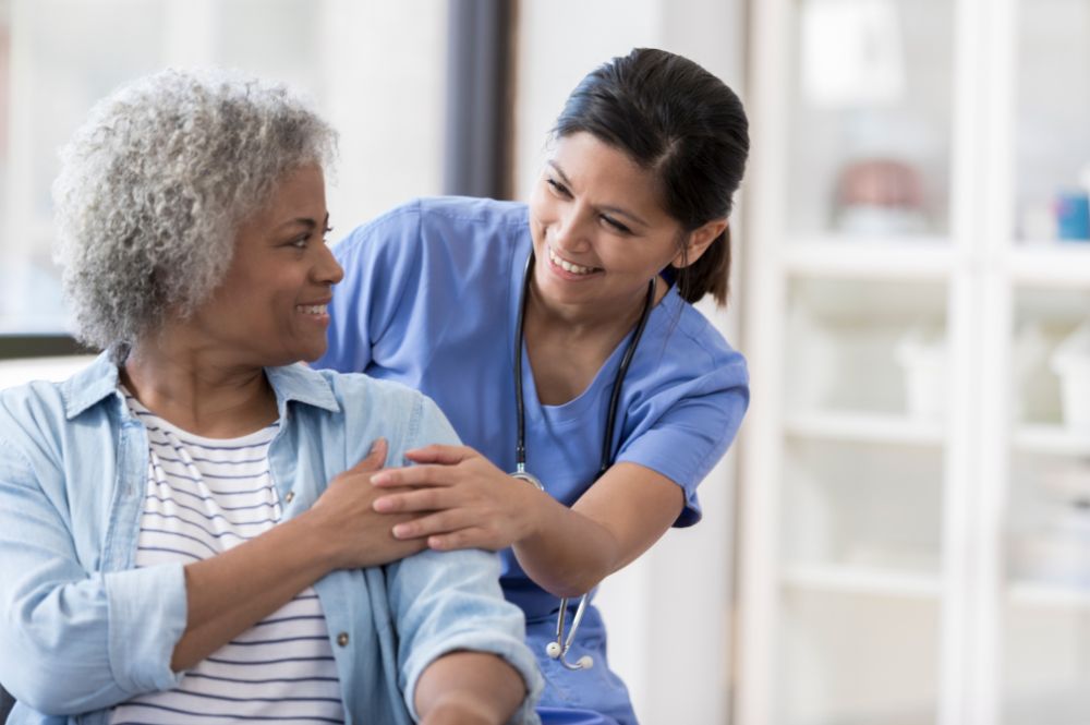 Nurse assists an elderly woman, highlighting the importance of rare disease patient recruitment in healthcare support.