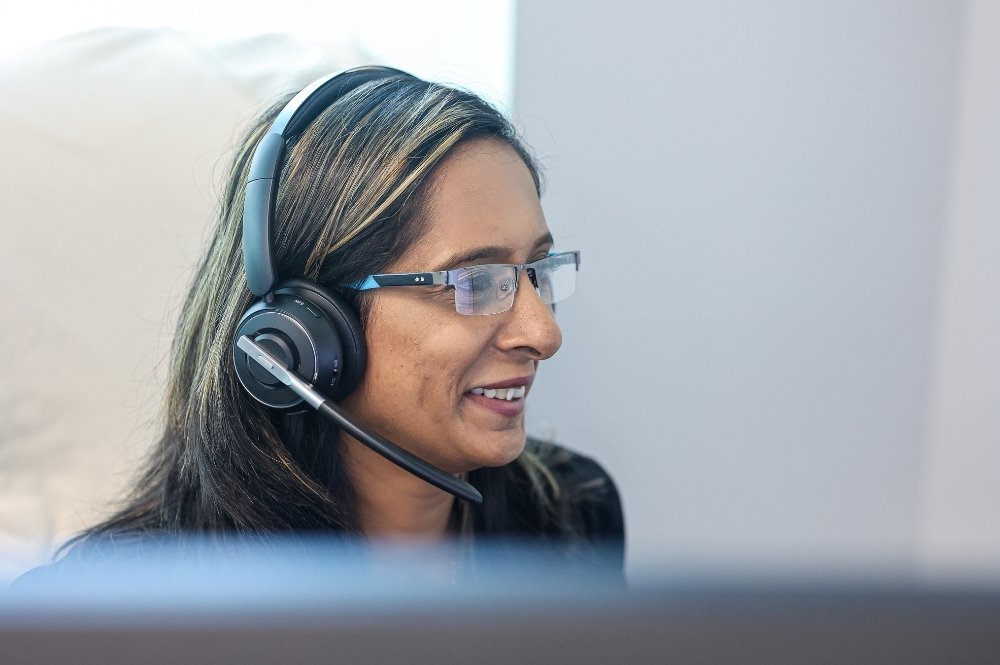 Woman in headset assisting with healthcare reimbursement support