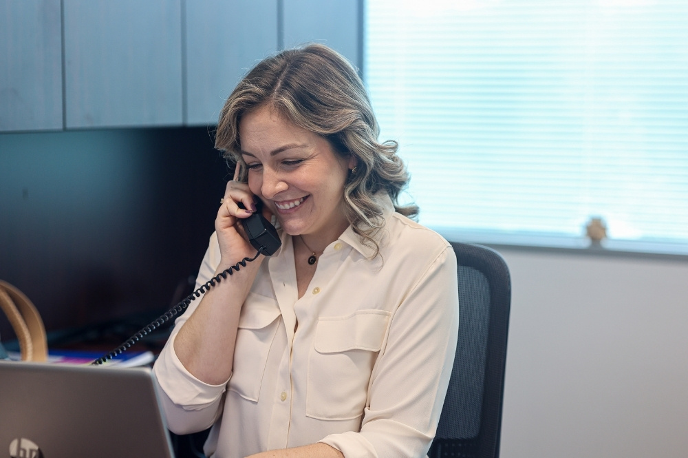 Smiling healthcare professional on a phone call, demonstrating patient trust and effective healthcare communication in clinical trial support.