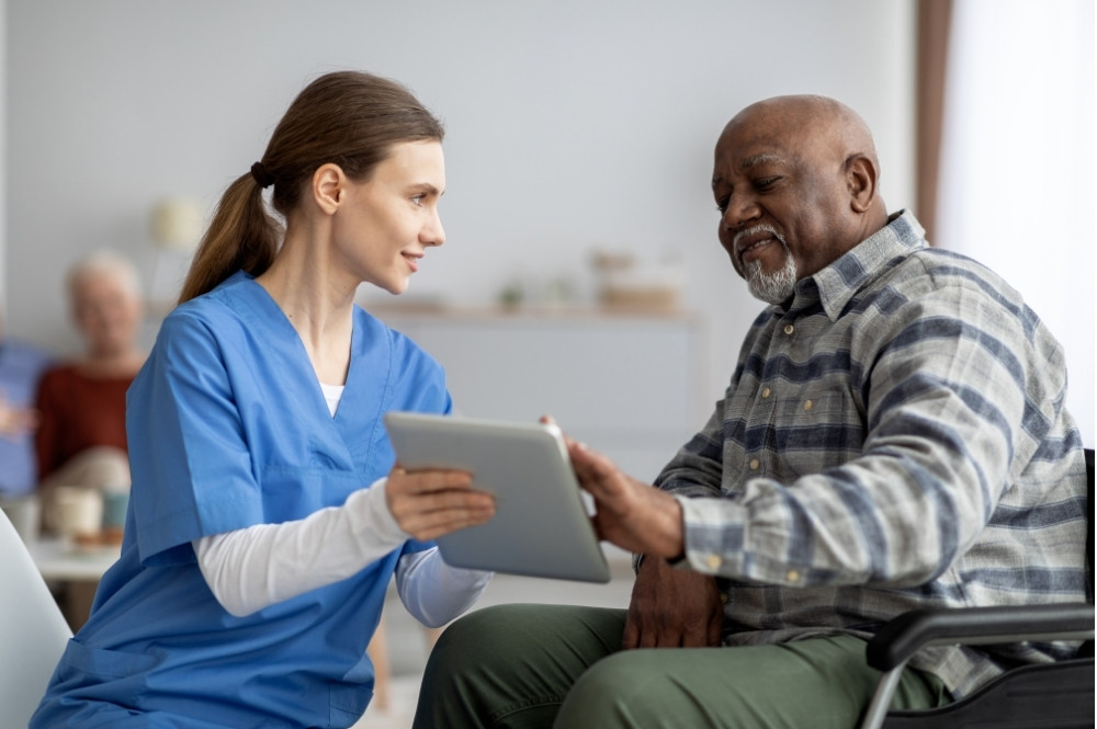 Nurse reviewing patient pre-screening information for clinical trials with a potential participant