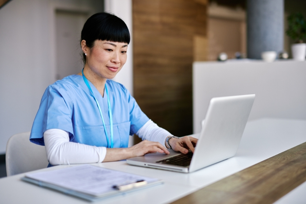 Healthcare professional using a laptop to support specialty therapy patient support programs